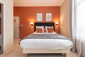 索姆河畔的圣瓦列里Hôtel Échappée en Baie - Parking privé gratuit dont forfaits bornes électriques réservable的一间卧室配有一张带橙色墙壁的大床