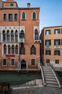威尼斯帕拉佐普瑞里酒店的运河旁的砖砌建筑,设有楼梯