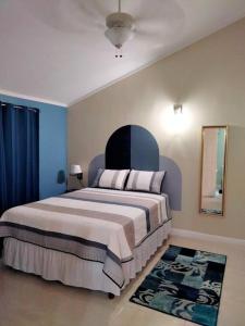 金斯敦Comfy Seascape Retreat near Kingston Airport的一间卧室设有一张蓝色墙壁的大床