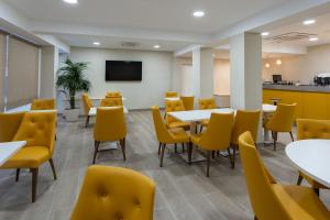 坎普罗东Hotel SAIOLA的用餐室配有桌子和黄色椅子