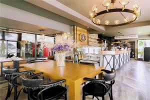 华欣Hua Hin Soi 7 - Ji Ya的一间带木桌和椅子的用餐室