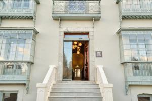 纳隆河畔穆罗斯HOTEL BOUTIQUE VILLA DEL MARQUÉS的白色的建筑,楼梯通往门