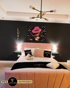 博勒姆伍德Luxury, 4 Bedroom House, FREE Parking, Borehamwood的一间卧室配有一张带粉红色床头板的大床