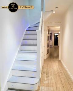 博勒姆伍德Luxury, 4 Bedroom House, FREE Parking, Borehamwood的一间有蓝色和白色楼梯的房间