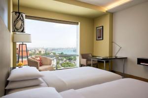 艾哈迈达巴德艾哈迈达巴德凯悦酒店的酒店客房设有两张床和大窗户。