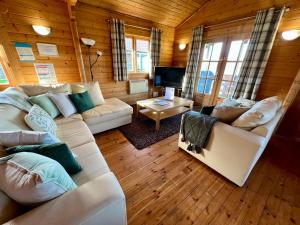 南塞尔尼Reeds Lodge, Lake Pochard的客厅配有白色沙发和电视