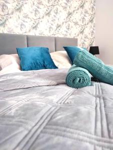 吉日茨科Apartament DanHouse的一张带蓝色枕头和绿色毛巾的床