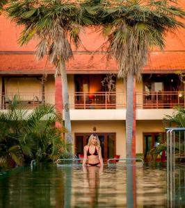 乌隆他尼Nakara Villas & Glamping Udon Thani的站在水体中的比基尼妇女