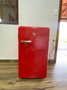 皮乌米Chalés Vista da Serra的红色冰箱坐在房间里