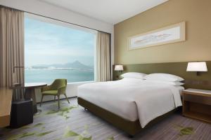 香港香港东涌世茂喜来登酒店的一间卧室设有一张大床和一个大窗户