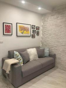 伊夫雷亚CASA TUA的客厅配有灰色的沙发和墙上的照片