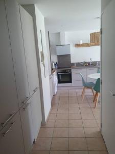比斯卡罗斯Mignon appartement en résidence avec piscine的厨房配有白色家电,铺有瓷砖地板。