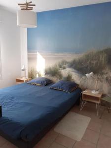比斯卡罗斯Mignon appartement en résidence avec piscine的一间卧室配有一张蓝色的床和海滩壁画