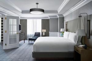 华盛顿华盛顿特区丽思卡尔顿酒店的酒店客房带一张大床和一把椅子