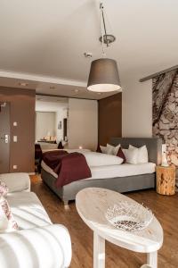 巴特维塞Hotel Villa Lago Garni的一间卧室配有两张床、一张桌子和一张沙发