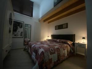切里尼奥拉B&B Belvedere的一间卧室配有一张床和一张带台灯的桌子