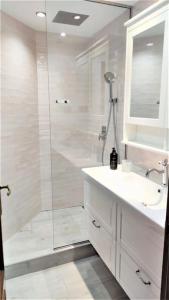 纳瓦塞拉达Apartamento en Navacerrada的带淋浴、盥洗盆和镜子的浴室