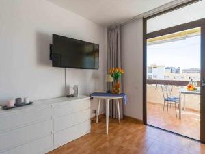 圣巴托洛梅Marlenghi Apartments 412的客厅配有电视和鲜花桌