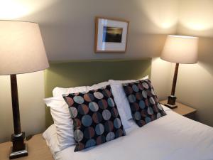 RaasayRaasay House Hotel的一间卧室配有两盏灯和一张带枕头的床。