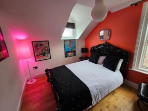 朴次茅斯Southsea Royale James Bond 3 bed Cool Penthouse, seafront parking的卧室设有红色的墙壁和一张带白色床单的床