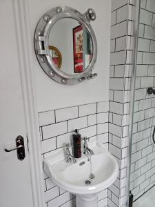 朴次茅斯Southsea Royale James Bond 3 bed Cool Penthouse, seafront parking的浴室设有白色水槽和镜子