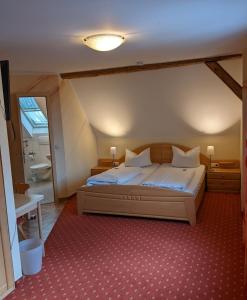 楚斯马尔斯豪森阿德勒客栈酒店的一间带大床的卧室和一间浴室