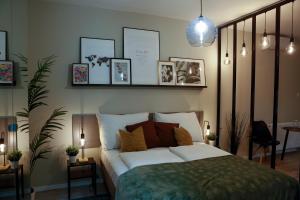 布达佩斯阿卡法假日公寓的卧室配有一张白色床,墙上挂有照片