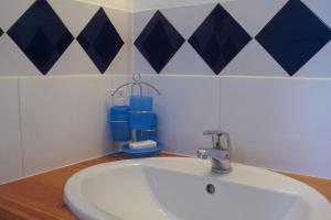 奥特朗Gîte EDELWEISS - 4 personnes - "Les Gites du Chalet" à Autrans的浴室设有水槽和蓝色及白色瓷砖