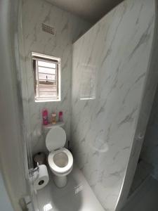 利文斯顿Kasuda Rooms - Cosy self contained rooms的白色的浴室设有卫生间和窗户。