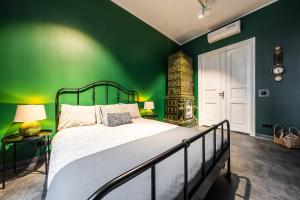 卡托维兹LivingRoom 2 z wanną z hydromasażem的绿色卧室,配有床和绿色的墙壁