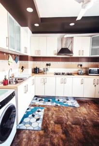 胡鲁马累Charming Beachfront 2BR Apartment in Hulhumale’的厨房配有白色橱柜和瓷砖地板。