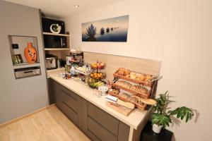阿尔贝维尔Le Lotus Blanc的厨房配有带面包和食物的柜台