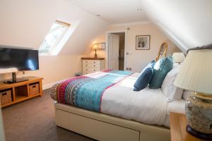 福克斯通Terlingham Lane Cottage的一间卧室设有一张床、电视和窗户