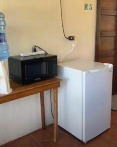 Santa ElenaDrift Inn Cayo的冰箱旁的桌子上有一个微波炉