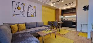 斯科普里Exclusive & Modern Apartment的客厅配有沙发和桌子