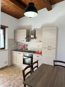 MeggianoAgriturismo Tre Monti的厨房配有桌子和炉灶。 顶部烤箱