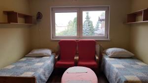 谢拉兹noclegi pokoje gościnne kwatery pracownicze Dobranocka的客房设有两张单人床和一扇窗户。