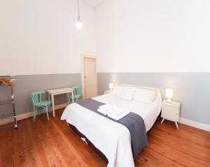 布宜诺斯艾利斯LOPEZ Hostel & Suites的卧室配有一张床和一张桌子及椅子