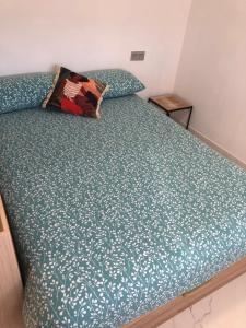 伊伦Apto. BLAIA的一张带绿色棉被的床和一个枕头