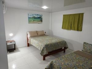 圣安德烈斯LodgeFabi'sPlace的一间卧室配有一张床、一张桌子和一个窗户。