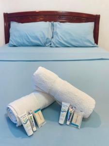 美岸ROMY'S PLACE - ENTIRE 3RD FLOOR APARTMENT的一张带两卷内衣和两条毛巾的床