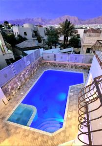 埃拉特VILLA SHUNIT- וילה שונית by barak royal suites的一座大型蓝色游泳池,位于一座建筑的顶部