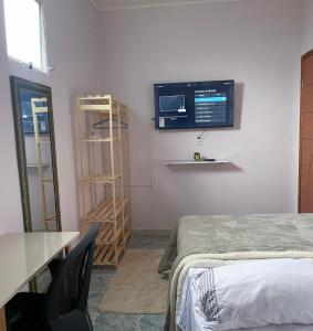 马瑙斯Residencial Napolitan的一间设有床铺和墙上电视的客房