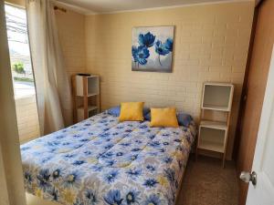 科金博Casa a pocos minutos de playa La Herradura的一间卧室配有蓝色和黄色枕头的床