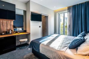 斯普利特Calma Luxury Rooms的配有一张床、一张书桌和一扇窗户的酒店客房