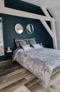 敦刻尔克Nuitées / télétravail的一间卧室配有一张带蓝色墙壁和镜子的床