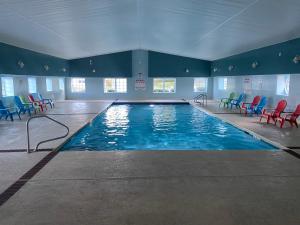 米斯蒂克泰伯酒店的一座大型游泳池,里面设有五颜六色的椅子