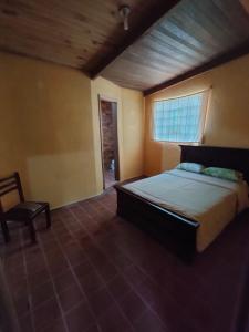 基多Pululahua Magia y Encanto的一间卧室配有一张大床和一把椅子