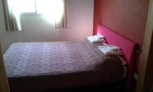 圣马科斯塞拉Casa-monte的一间小卧室,配有一张带粉红色床头板的床