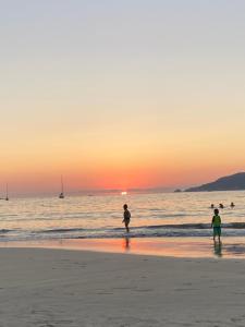 伊斯塔帕Casa ALOA Ixtapa的日落时分两人站在海滩上